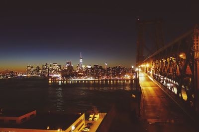 Illuminated bridge over river at night