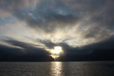 Scenic view of sea against dramatic sky during sunset