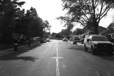 Road amidst trees against sky