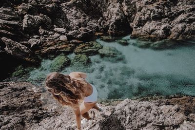 High angle view of woman walking on rocks over lake