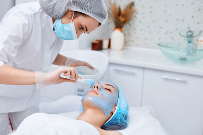 Midsection of dentist examining patient in clinic