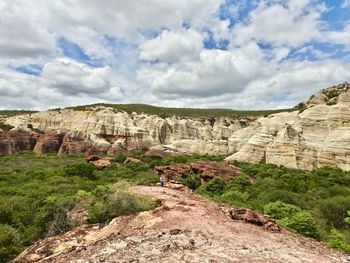 Rock formations on landscape against cloudy sky