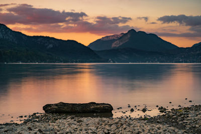 Scenic view of lake against mountains during sunset