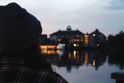 Rear view of woman looking at illuminated buildings against sky