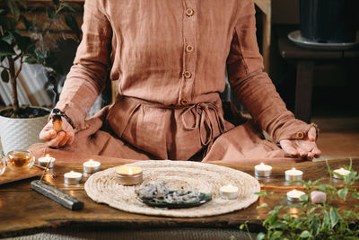 Woman meditating with palo santo in studio, cleaning space with smoke.  incenses at home