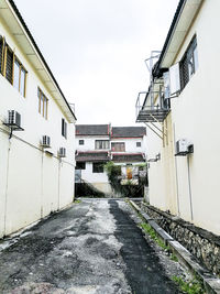 Road amidst buildings against sky