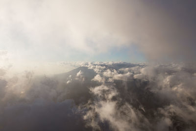 Aerial view of clouds over mountain against sky