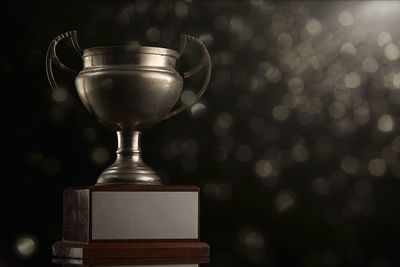 Close-up of trophy on table against illuminated lights