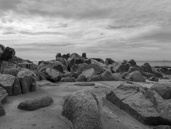 Rocks by sea against sky