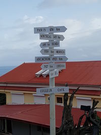 Low angle view of information sign against sky