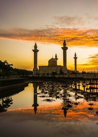 Reflection of tower in water during sunset