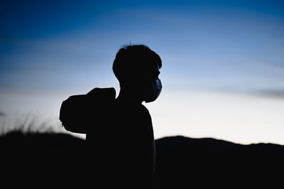 Silhouette in golden hour of young man look at view and thoughtful in confident emotion