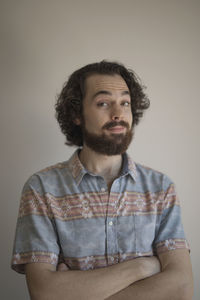 Portrait of man standing against gray background