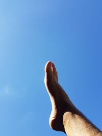 Low angle view of man against clear blue sky