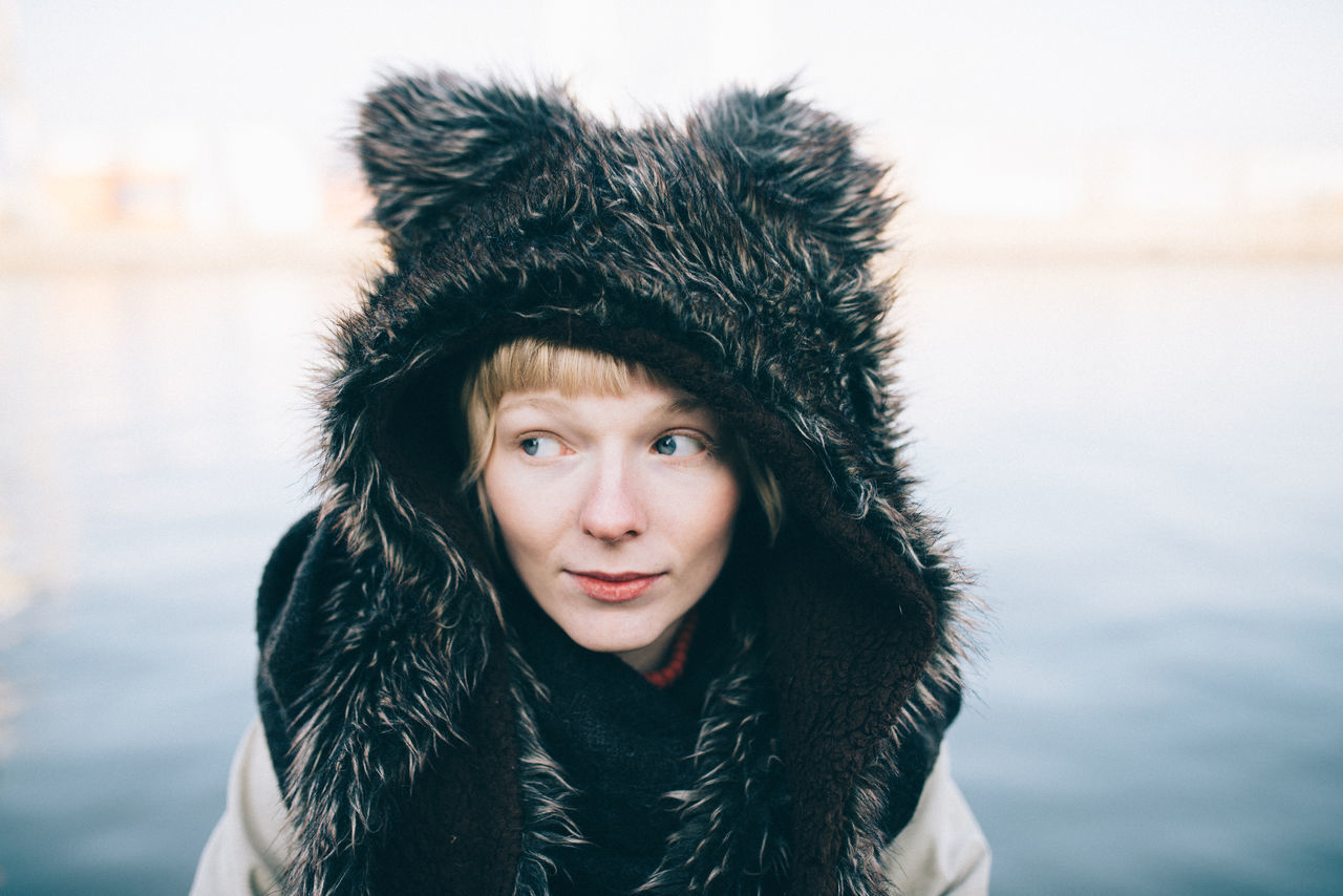 Woman in fur coat against sky