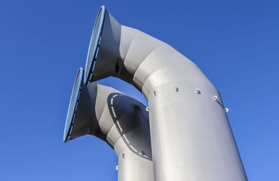 Low angle view of telephone pole against clear blue sky