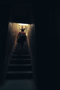Low angle view of man standing on staircase in building