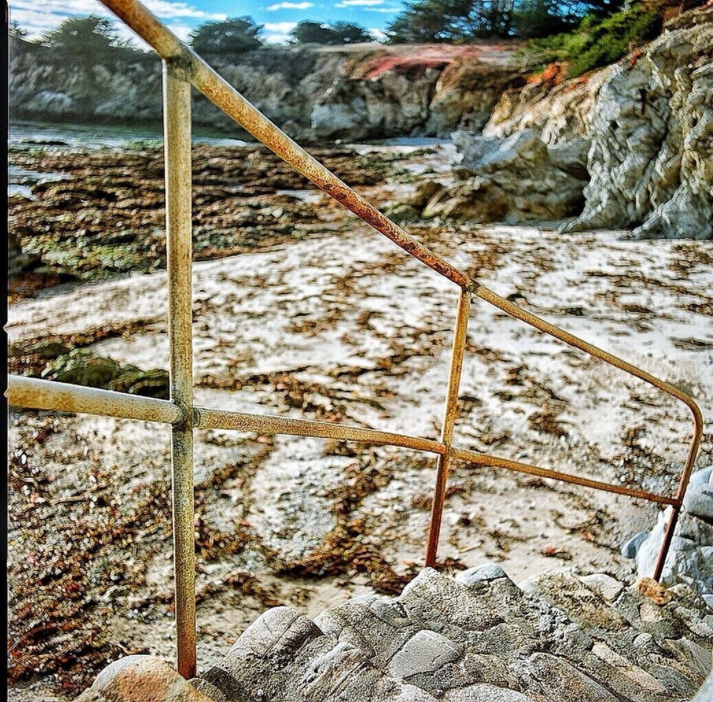 rock - object, stone - object, sunlight, wood - material, day, no people, mountain, nature, outdoors, metal, tranquility, railing, textured, stone, sky, tranquil scene, stone wall, rock, built structure, fence