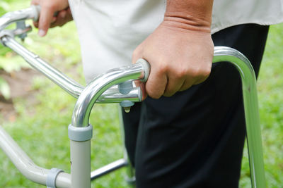 Midsection of man holding bicycle while standing outdoors