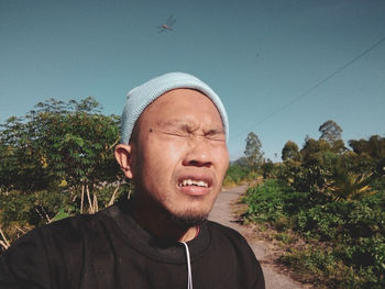 Portrait of man against plants against sky