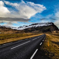 Empty road with mountains in background