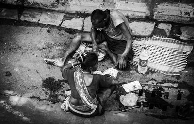 High angle view of men sitting on street