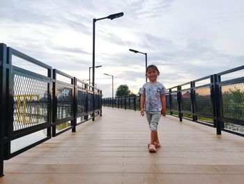 Full length of woman standing on bridge