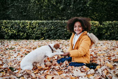 Portrait of smiling woman with dog during autumn
