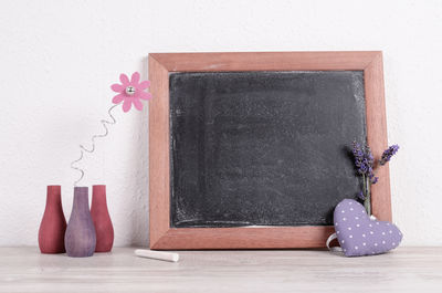 Close-up of white flowers on table against wall