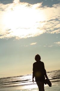 Rear view of silhouette man standing at beach