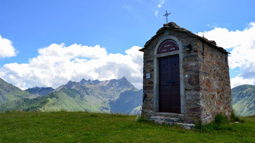 Low angle view of cross on field against sky