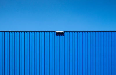 Low angle view of metal against blue sky