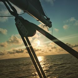 Low angle view of silhouette hanging over sea against sky