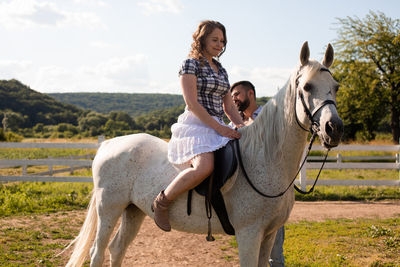 Woman riding horse on land