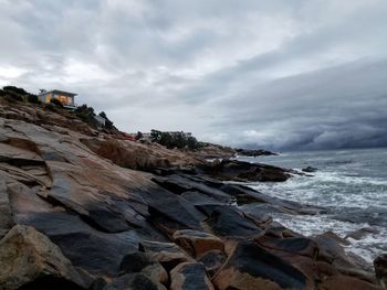 Scenic view of rocks on beach against sky