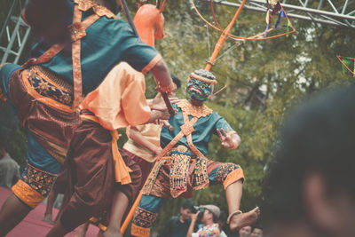 Tilt shot of men in costumes dancing during festival