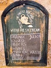 Close-up of information sign on wooden wall