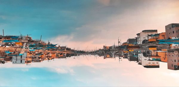 Panoramic view of buildings by river against sky