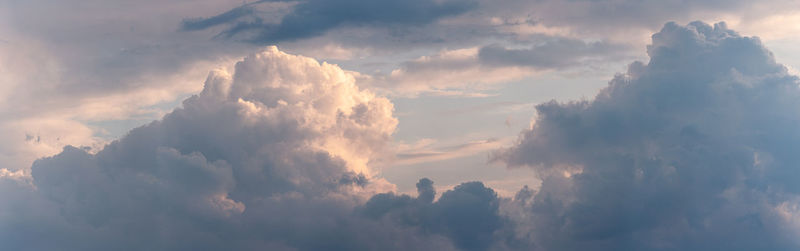 Low angle view of sunlight streaming through clouds