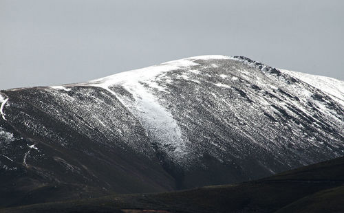 Low angle view of snowcapped mountain against clear sky