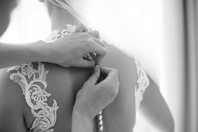 Bridesmaid adjusting dress of bride