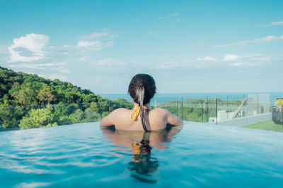 Rear view of woman swimming in pool