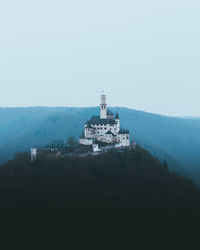 Low angle view of castle on mountain against clear sky