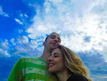 Low angle view of young woman against sky