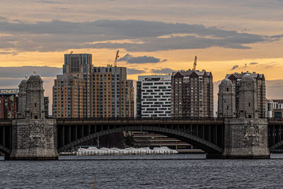 Bridge over river against buildings in city