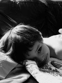 Portrait of smiling boy lying on bed