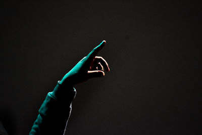 Close-up of hand holding light painting against black background