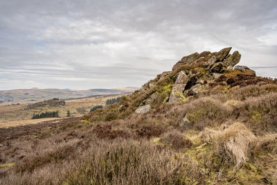 Rock formations on field against sky