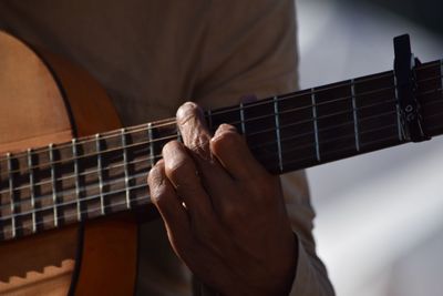 Close-up midsection of man playing guitar