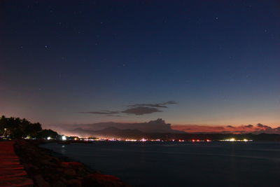 Scenic view of lake against sky at night